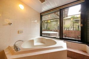 baño con bañera grande y ventana en Hotel Annex, en Sapporo