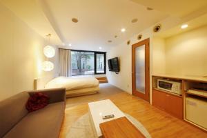 札幌的住宿－別館飯店，客厅配有沙发和1张床