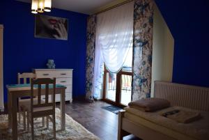 Habitación azul con mesa y comedor en Apartament na Falsztynie, en Falsztyn