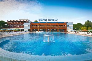 a large swimming pool in front of a building at Laguna Grande monolocali in Bibione