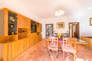 トッレ・サン・ジョヴァンニ・ウジェントにあるCasa Vacanza Sofiaのキッチン(木製キャビネット、テーブル、椅子付)
