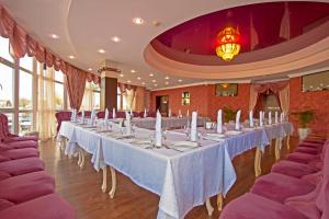 una fila de mesas en una habitación con sillas moradas en Captain Hotel, en Anapa