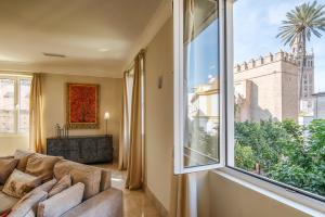 a living room with a couch and a large window at Puerta Principe Luxury Apartments in Seville +79 photos