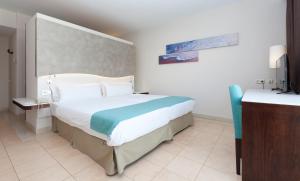 
a hotel room with a bed and a desk at Impressive Playa Granada Golf in Motril
