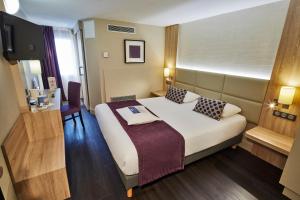 um quarto de hotel com uma cama e uma televisão em Kyriad Beaune em Beaune