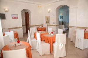 a dining room with two tables and white chairs at Palmed Hotel in Gizzeria