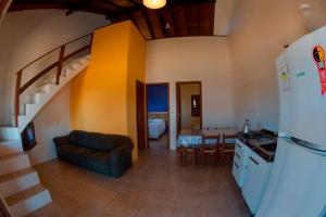 a kitchen and a living room with a spiral staircase at Apoena Casas de Aluguel in Laguna