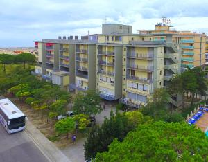 a large building with a bus parked in front of it at Laguna Grande monolocali in Bibione