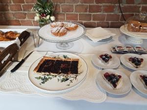 una mesa cubierta con platos de pastel y bollería en Maison Louis, en Trofarello