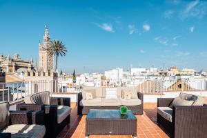 a balcony with furniture and a view of a city at Puerta Principe Luxury Apartments in Seville