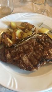 a steak and potatoes on a white plate at Dolce Bungalow R5915 in Pula