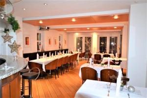 ein Esszimmer mit Tischen und Stühlen in einem Restaurant in der Unterkunft Hotel-Weinstube Weinhaus Steppe in Waldbronn