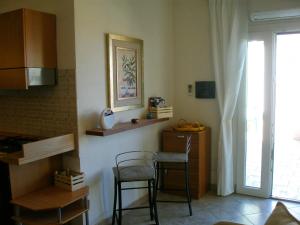 ヴァッレドーリアにあるAppartamento LE TERRAZZE DEL MARE località la CIACCIAのキッチン(テーブル、椅子2脚付)、窓が備わります。