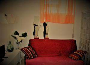 ペスカーラにあるI Gemelli Holiday Houseの赤いソファーの壁に猫が2匹