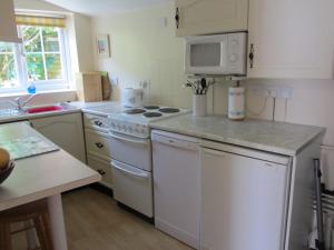 eine Küche mit weißen Geräten und einer weißen Mikrowelle in der Unterkunft The Stable in Eastleigh