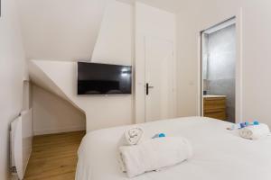 - une chambre avec un lit, une télévision et des serviettes dans l'établissement CMG Rivoli/ Notre-Dame I, à Paris