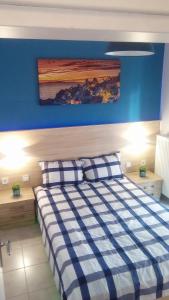 a bedroom with a bed with a blue wall at Amazing Apartment In The Center in Alexandroupoli