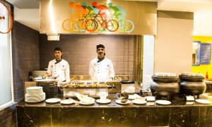 two chefs standing in a kitchen preparing food at Regency Tirunelveli By GRT Hotels in Tirunelveli