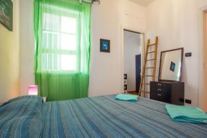 um quarto com uma cama com uma cortina verde e uma janela em Casa Ibiscus x2 em Palermo