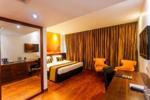 Habitación de hotel con cama y escritorio en Renuka City Hotel, en Colombo