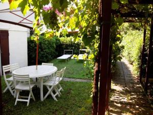 a white table and chairs in a yard with an umbrella at Garden House Pompei Vesuvio in Trecase