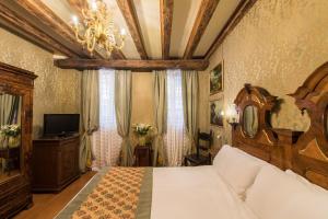 ヴェネツィアにあるホテル カサ ニコロ プリウリのベッドルーム1室(大型ベッド1台、シャンデリア付)