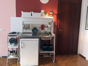 una pequeña cocina con fregadero junto a una pared roja en Up to four, en Milán