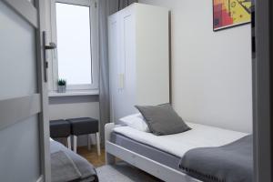 a small bedroom with a bed and a window at Nest Optima Toruń in Toruń