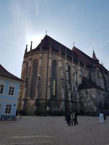 Eine Gruppe von Menschen steht vor einer Kirche in der Unterkunft Luky10 in Braşov