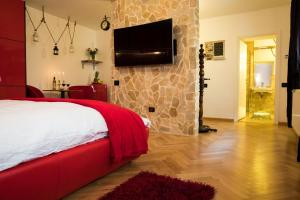 ein Schlafzimmer mit einem Bett und einem TV an einer Steinmauer in der Unterkunft Luky10 in Braşov