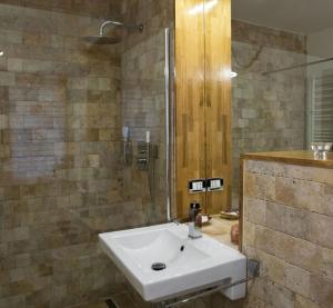 ein Badezimmer mit einem weißen Waschbecken und einer Dusche in der Unterkunft Luky10 in Braşov + 32 Fotos