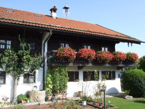 una casa con cajas de flores a un lado. en Gästehaus Banik en Seebruck
