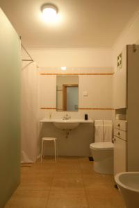 a bathroom with a sink and a toilet and a mirror at Casa da Tia Matilde in Sesimbra