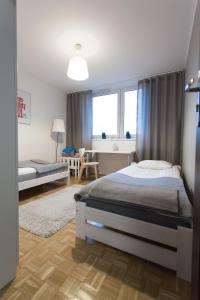 sypialnia z łóżkiem, biurkiem i oknami w obiekcie Nest Arena Toruń w Toruniu