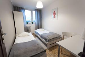 een kamer met twee bedden, een tafel en een raam bij Nest Arena Toruń in Toruń