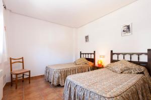 アルカラ・デ・ラ・セルバにあるCasa Rural Sauraのベッド2台と椅子が備わる客室です。