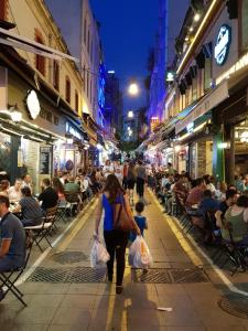 a woman and child walking down a street at night at My Kent Hotel in Istanbul
