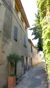 an alley with blue shutters on a building at le tilleul in Villevieille