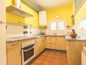 a kitchen with yellow walls and wooden cabinets at Los Prejones in Arenas de San Pedro +39 photos