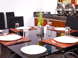 a table with white plates and glasses on it at Mount n Mist in Ooty