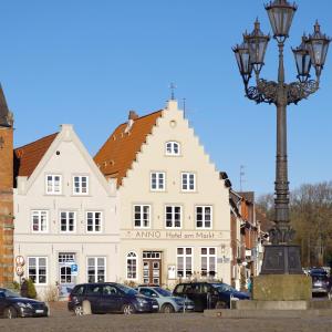 een groot wit gebouw met een straatlicht ervoor bij Hotel Restaurant Anno 1617 in Glückstadt