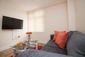 a living room with a gray couch and a table at DPV - Above Bar Street Apartments in Southampton