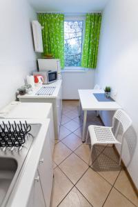 a kitchen with a sink and a table and a window at Nest Budget - nocleg dla firm in Toruń