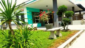 een bank voor een gebouw met planten bij Taiping Homestay Husna Afina in Taiping