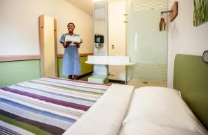 a doctor standing in a hospital room with a bed at SUN1 MIDRAND in Midrand