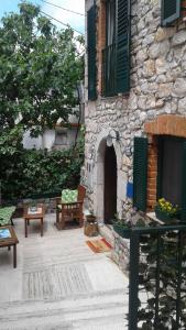 a patio with benches and a stone building at Apartment Tomecek in Selce