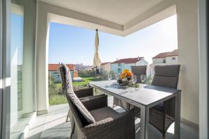 a dining room with a table and chairs on a balcony at Apartments M&L in Vodice