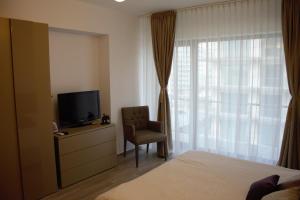 a bedroom with a bed and a chair and a television at Luxury Studio 42 De Silva in Mamaia