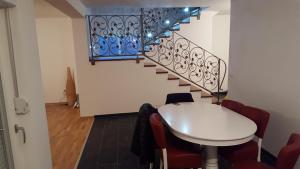 ein Esszimmer mit einem Tisch und einer Treppe in der Unterkunft Villa Buna in Buna
