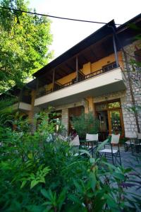 a building with tables and chairs in front of it at Hotel Papanastasiou in Elati Trikalon